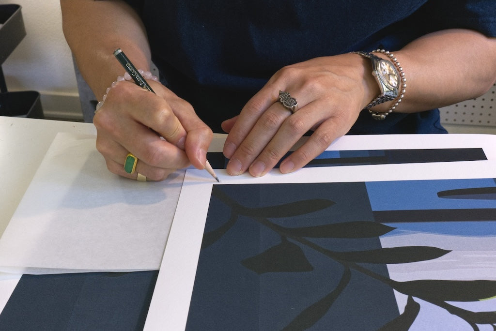 person signing semi-abstracted print of leaf design