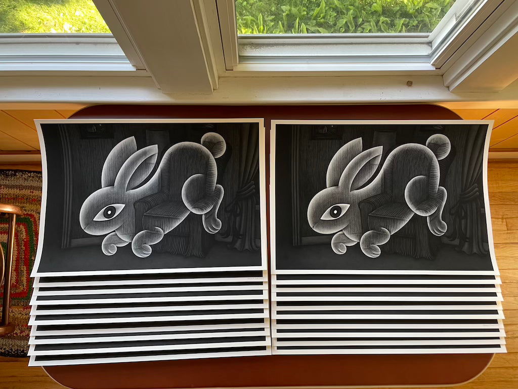 stacked black and white prints of a ghost rabbit floating in a living room