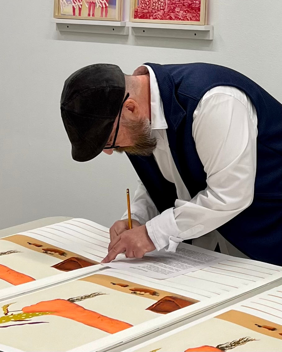 Photo of Gabe Langholtz signing his print of "Uprooted"