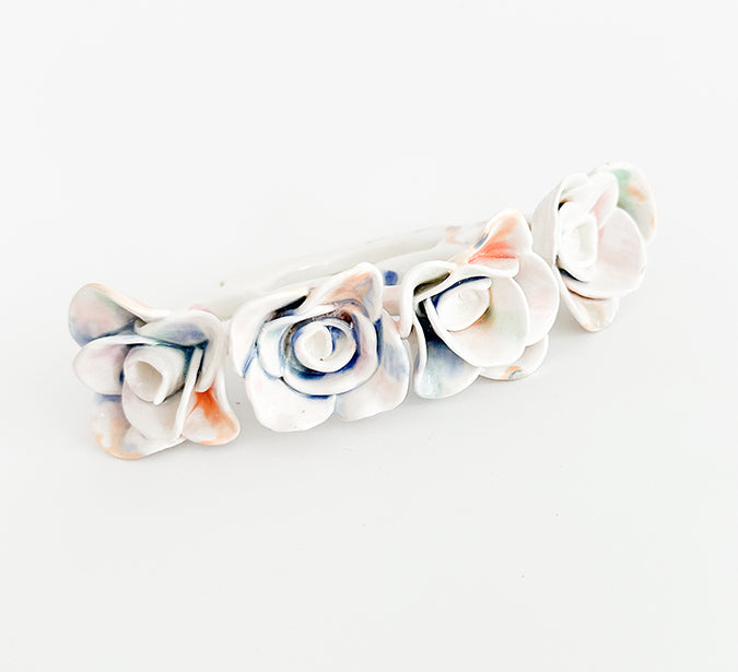 Photograph of a ceramic knuckle piece with multicolor roses by Jen Dwyer.