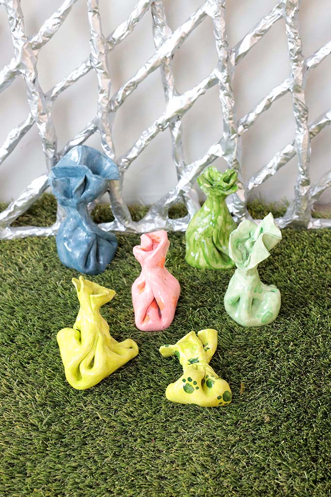 Ceramic sculpture of dog poop bag in various color