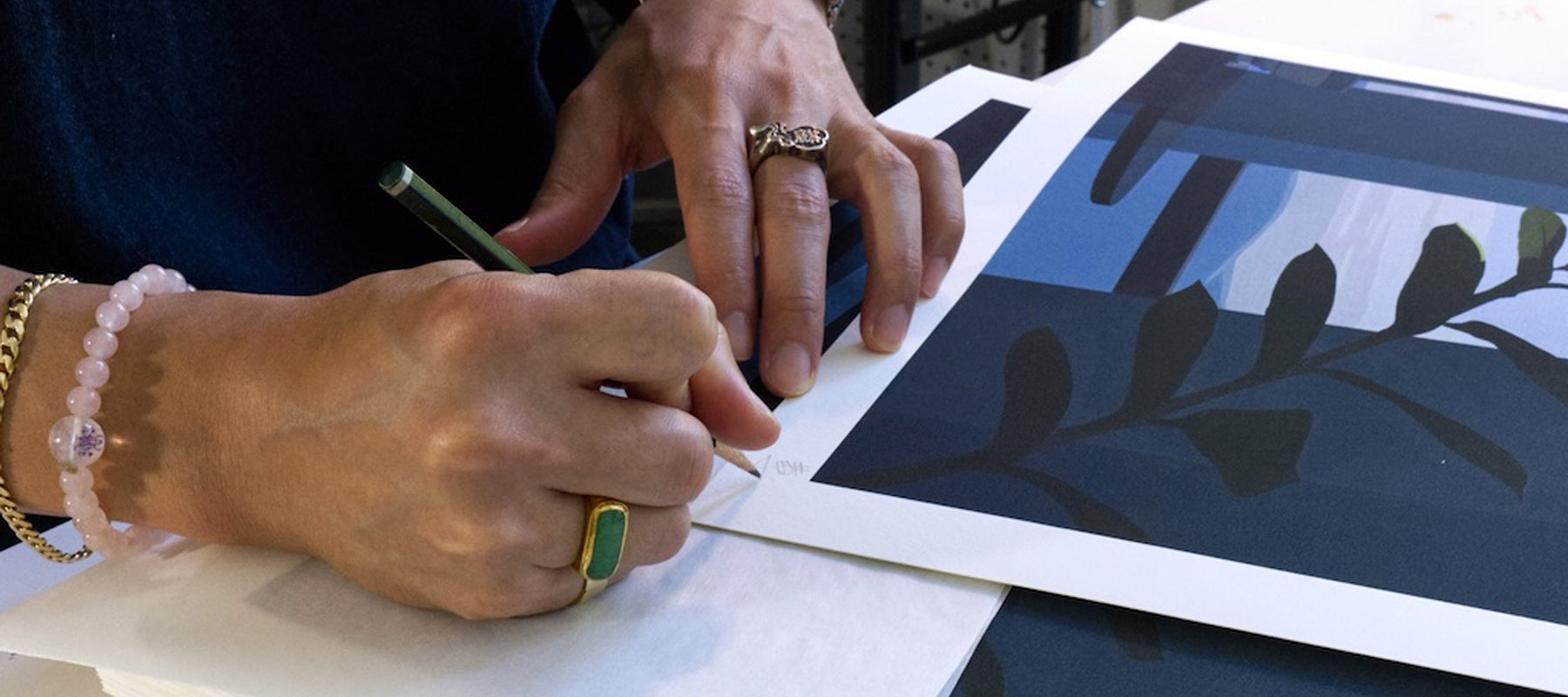 Person signing print of a leaf design.
