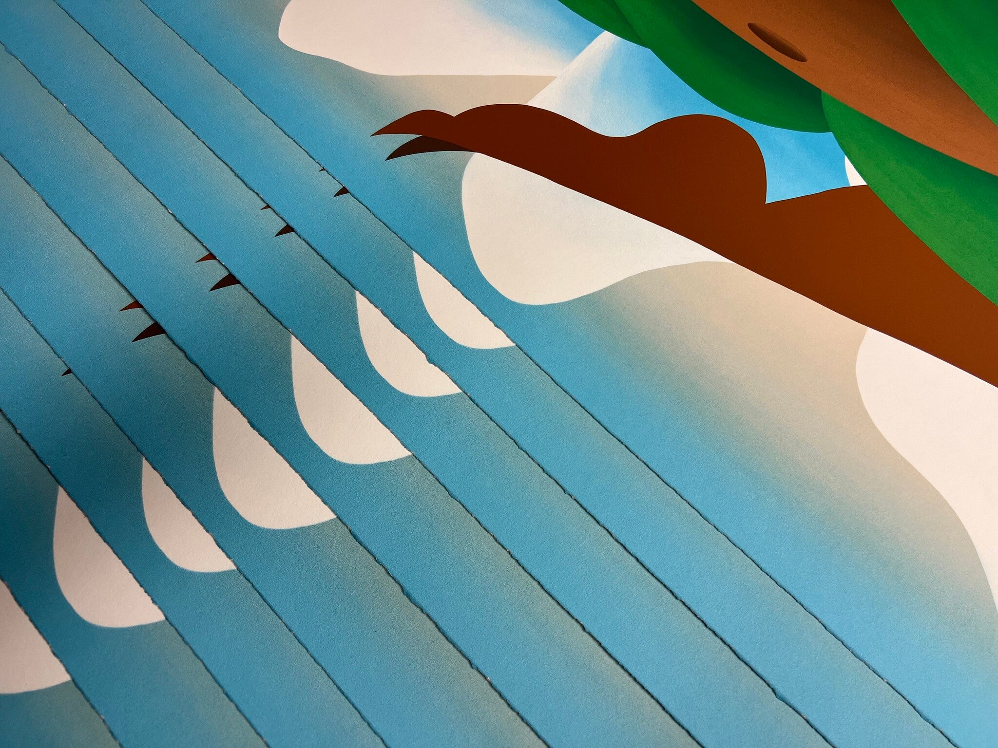 detail of Bianca Nemelc print fanned out - image shows blue sky, mountains and a rounded brown belly and foot pointed at sky