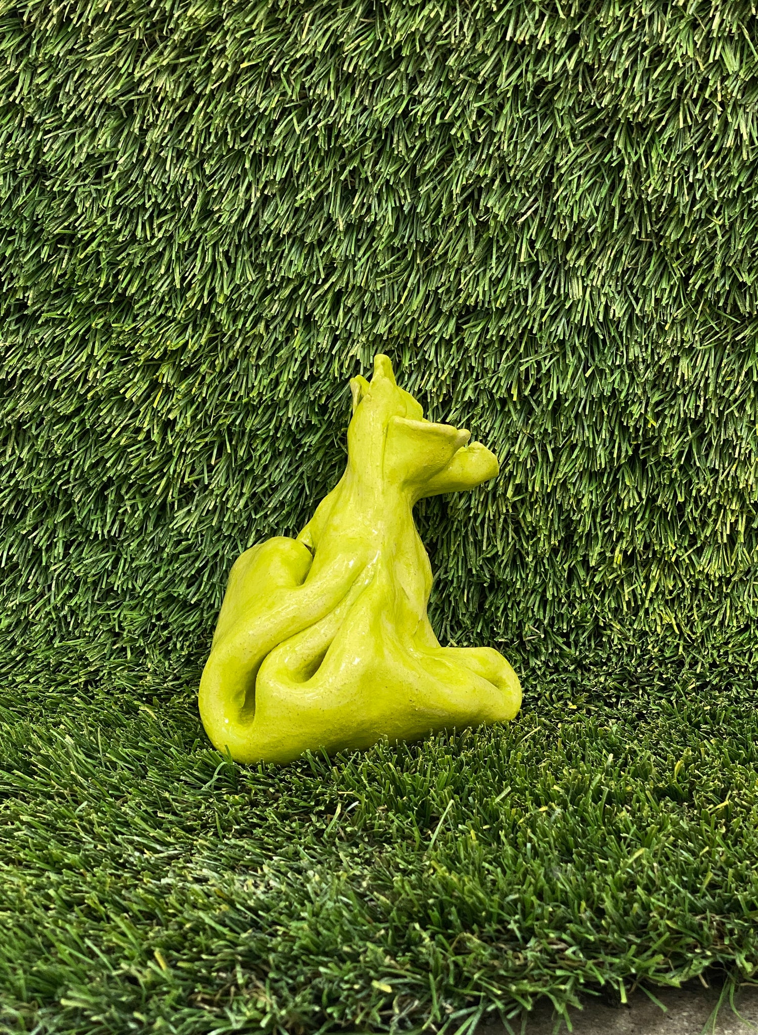 Ceramic sculpture of dog poop bag in lime green