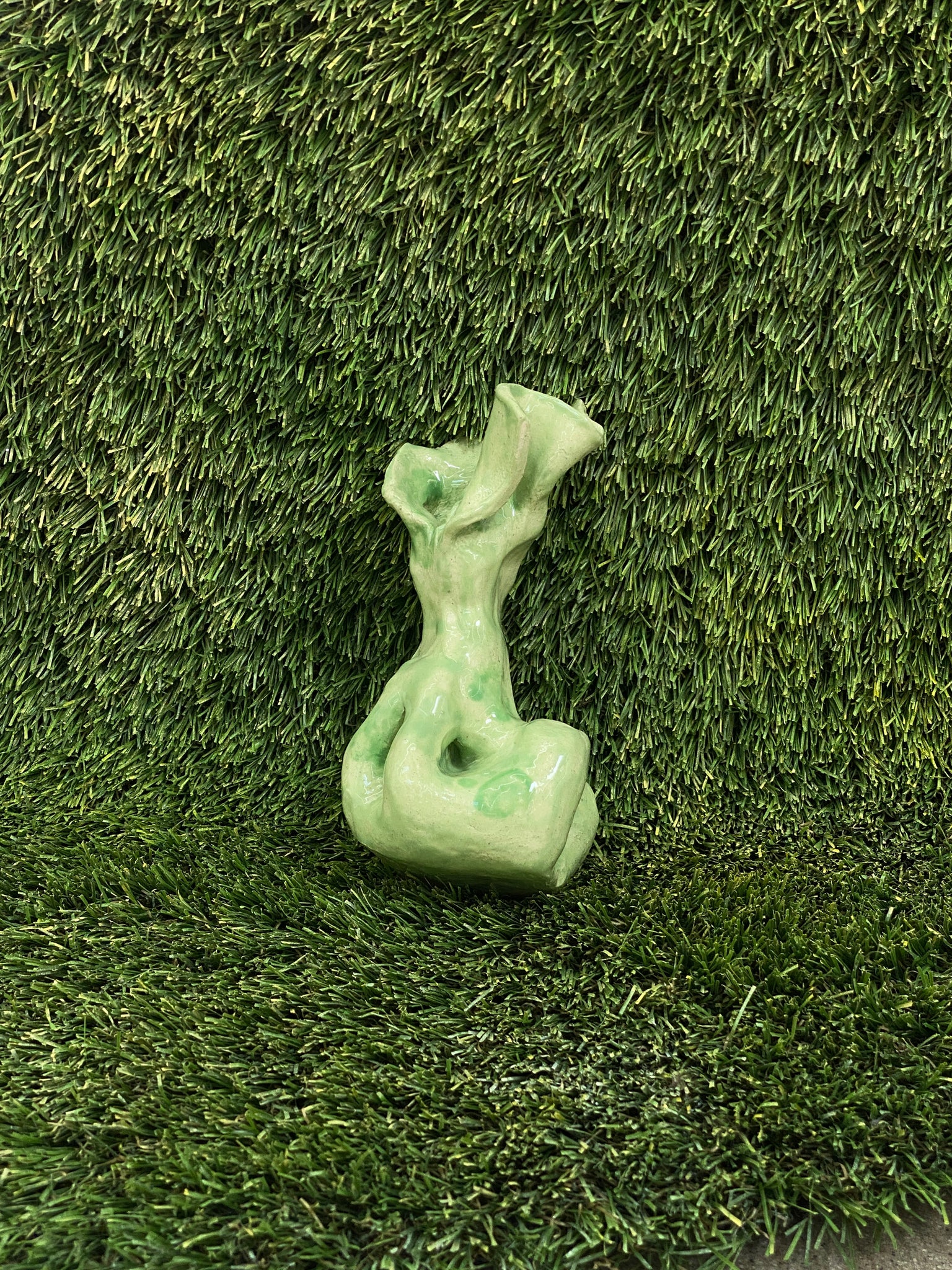 Ceramic sculpture of dog poop bag in light green